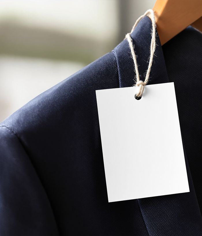 Navy suit jacket on a hanger wearing its 123Alterations QR tag